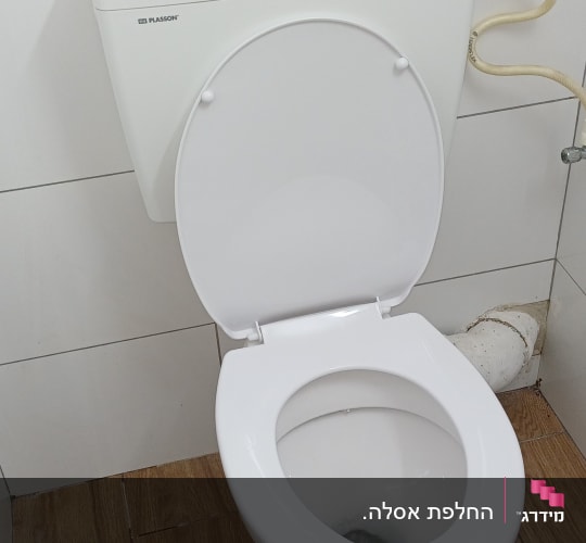 אסלה לבנה בחדר אמבטיה עם רצפת עץ